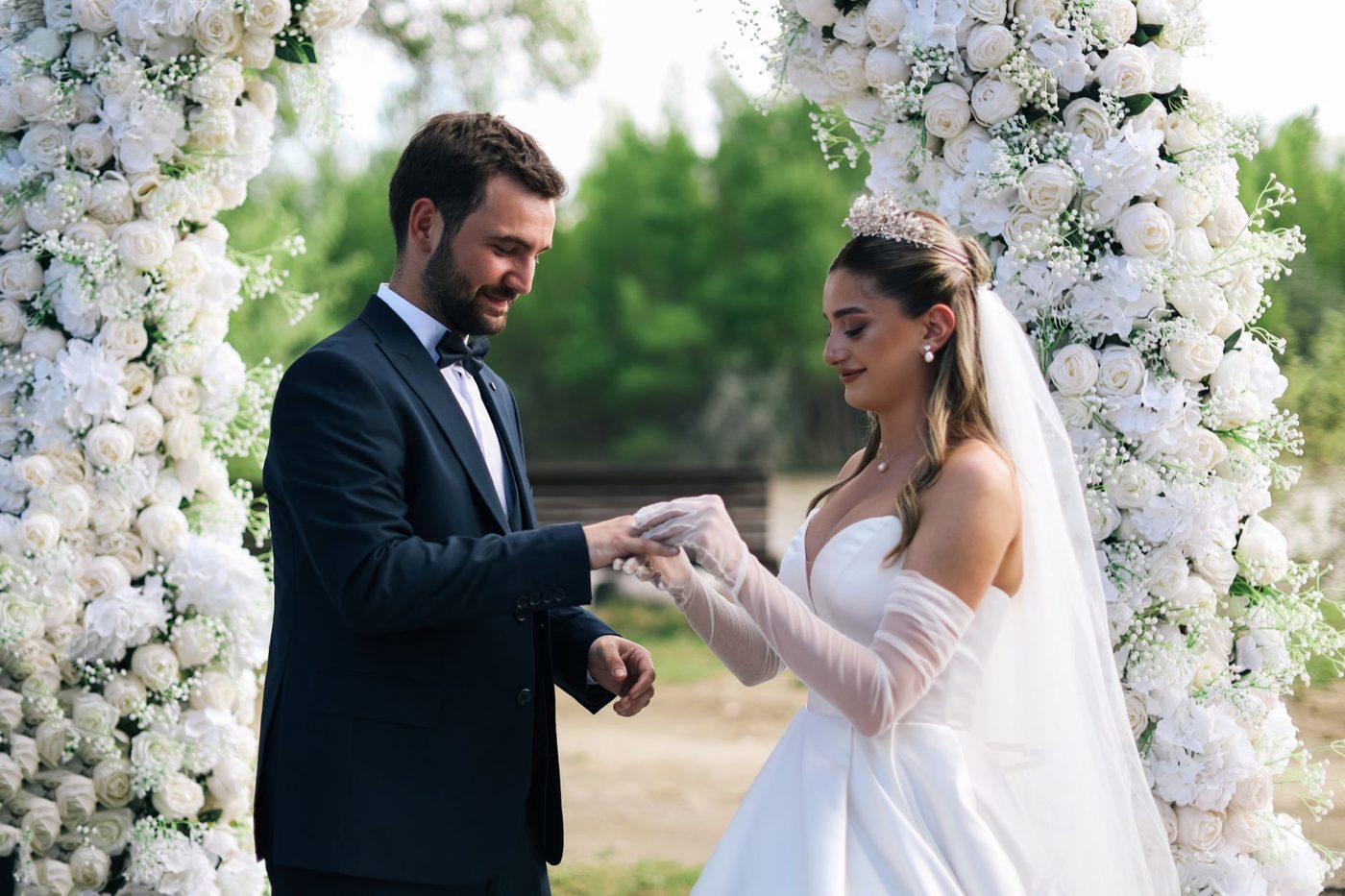 Couple holding hands and exchanging wedding vows during an outdoor ceremony