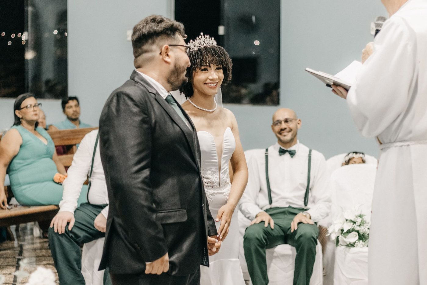 Groom reading his wedding vows to his bride while guests look on