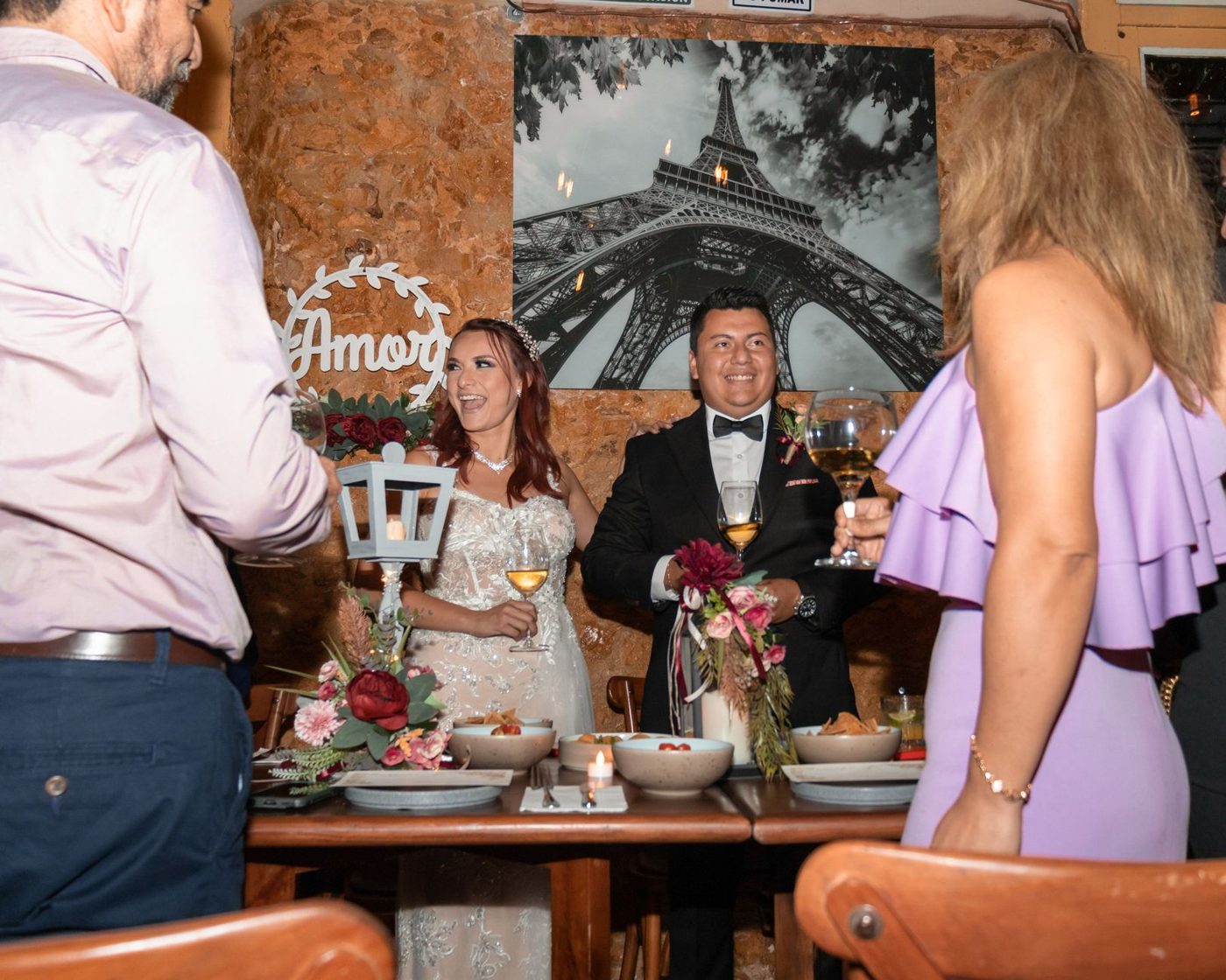 Groom raising a glass and giving a toast to guests at the wedding reception