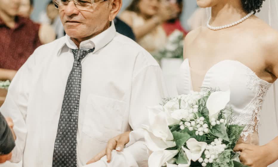 A father walks his daughter down the aisle at a warm wedding ceremony