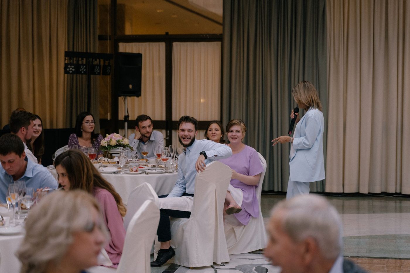 Father of the bride raising a glass while speaking to guests at a wedding reception