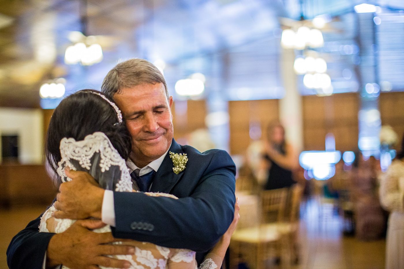 Father of the bride hugging his daughter in her wedding dress before the ceremony