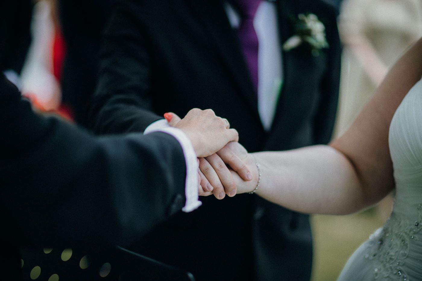 Couple facing each other and exchanging vows at an outdoor wedding ceremony