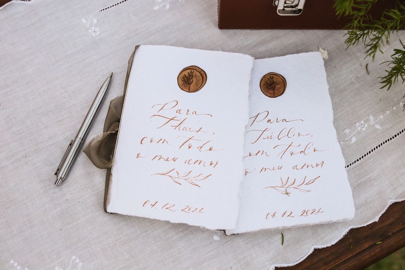 Handwritten wedding vow cards on a table next to a pen and a small bouquet