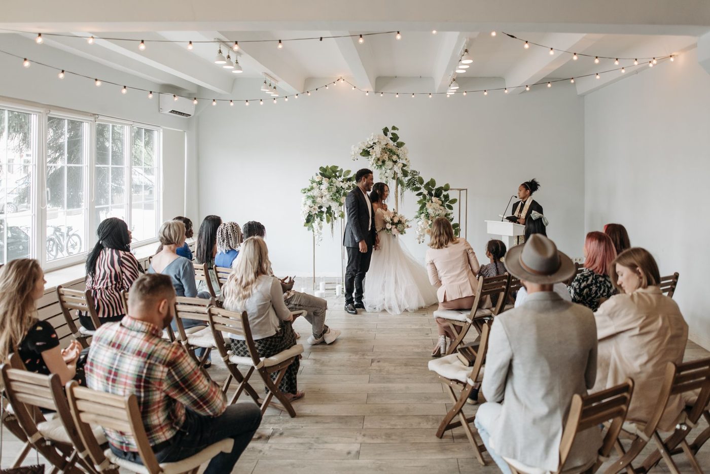 Couple standing with an officiant during a small, intimate wedding ceremony