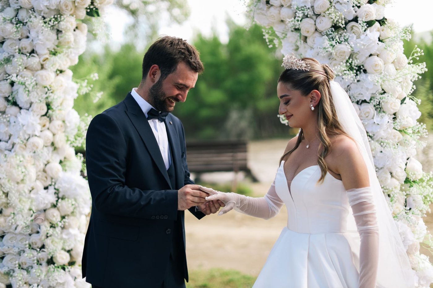 Couple facing each other holding hands as they begin their vows during an outdoor wedding ceremony