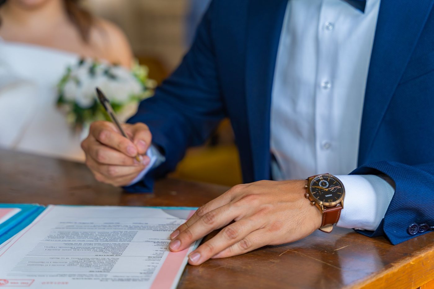Groom writing his wedding vows by hand on a notecard
