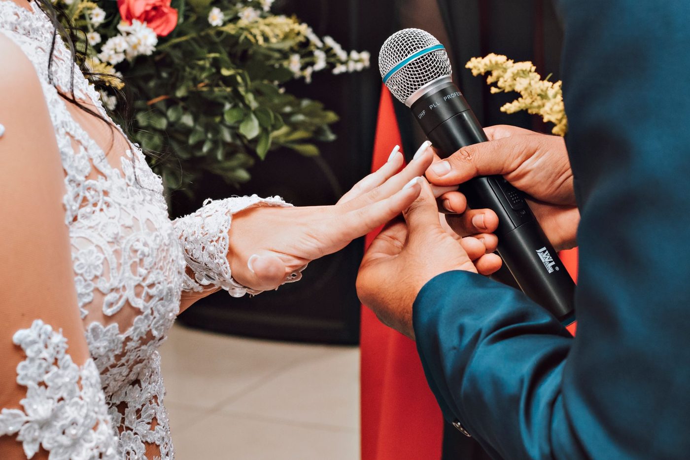 Groom and bride holding hands while exchanging vows at their ceremony