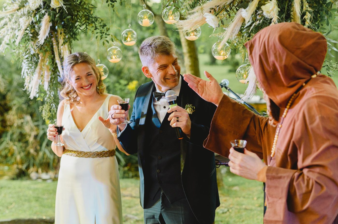 Groom standing with a glass raised giving a toast at the wedding reception