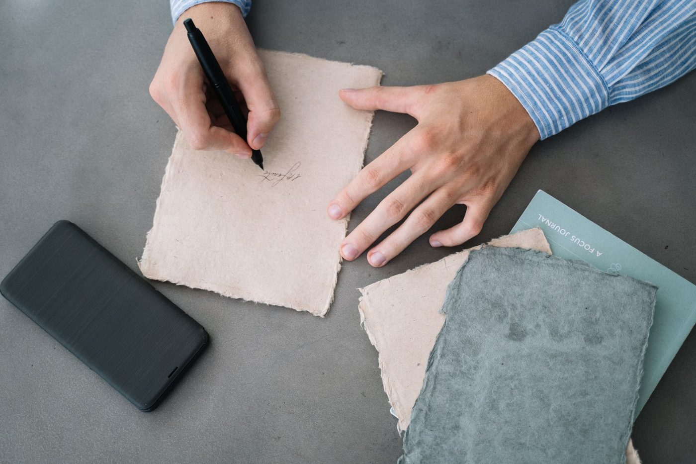 Handwritten notes and a pen on a table while a person drafts their wedding vows
