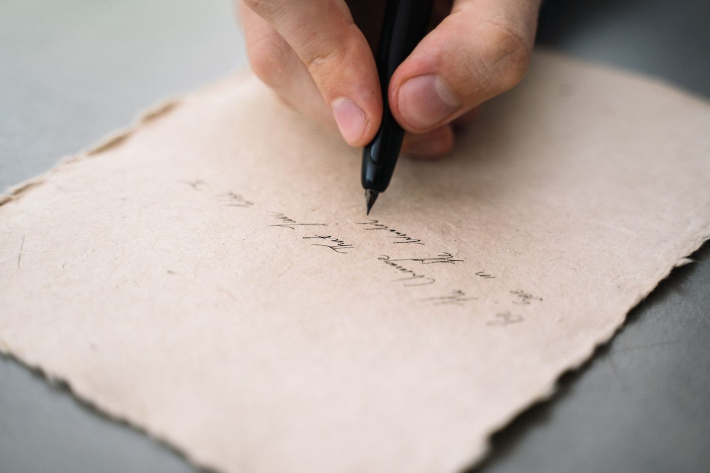 Handwritten wedding vows on a sheet of paper with a pen resting beside it
