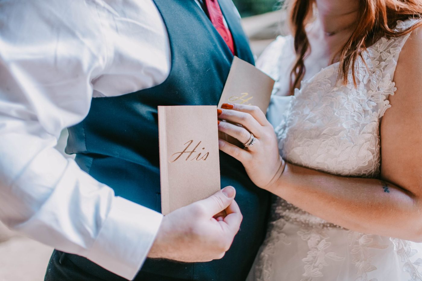 Groom reading his handwritten vows to his bride during an outdoor ceremony