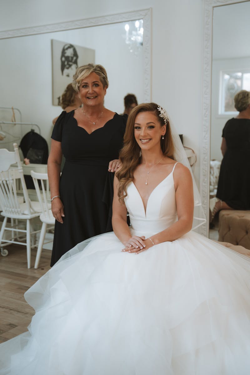 Mother of the bride laughing with wedding guests during the reception toast