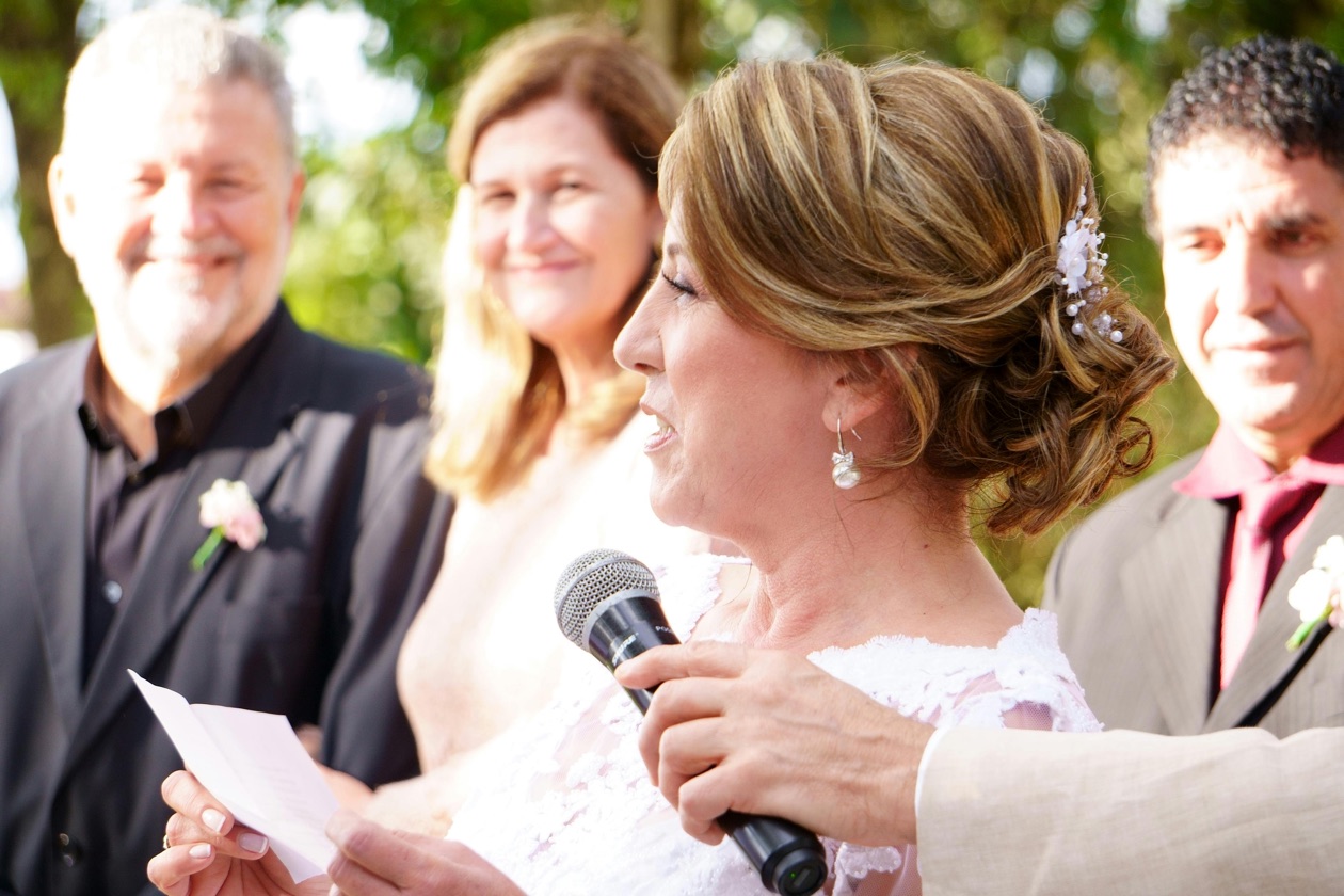 A woman delivers a heartfelt speech at an outdoor wedding ceremony