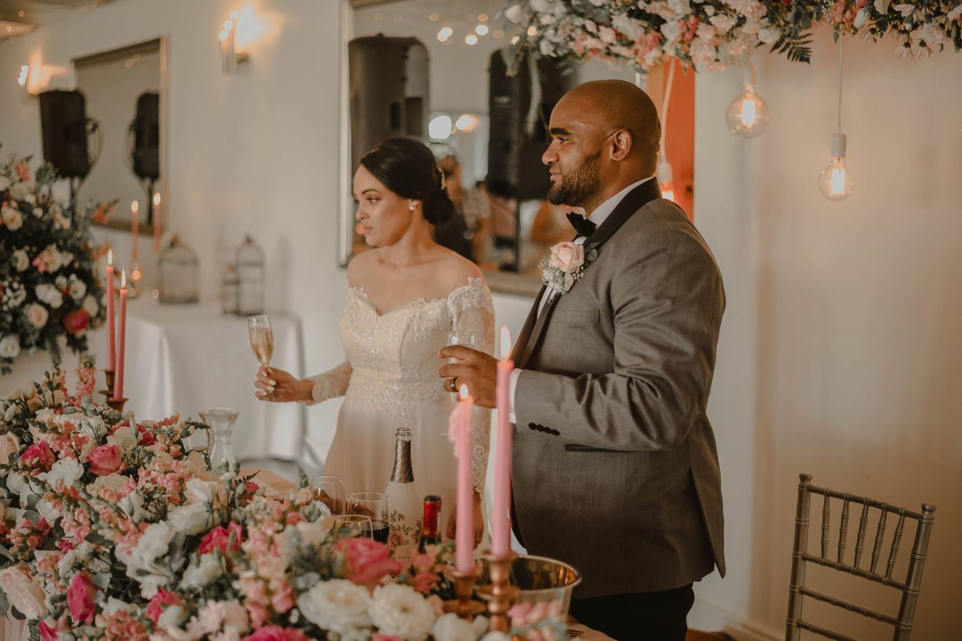 Groom raising a glass and giving a speech to guests at a wedding reception
