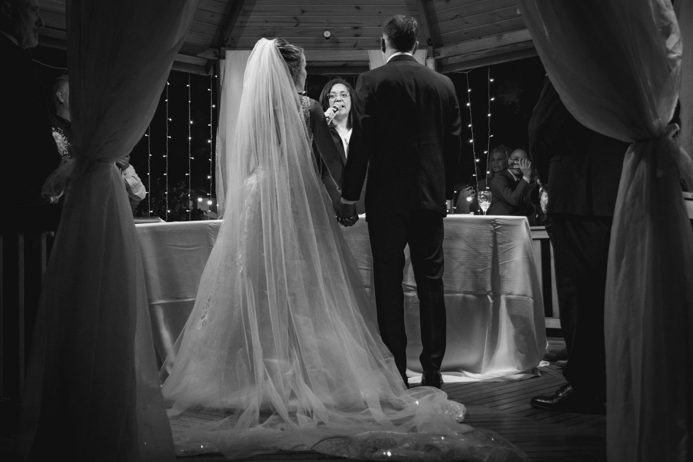 Bride reading her wedding vows to her groom during an outdoor ceremony