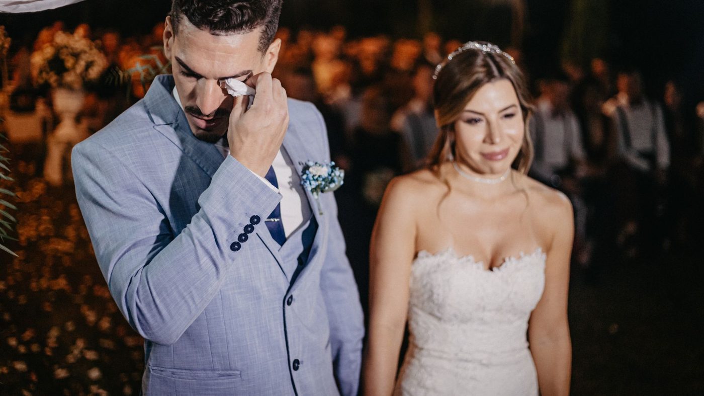 Emotional groom wiping a tear as his bride reads her vows