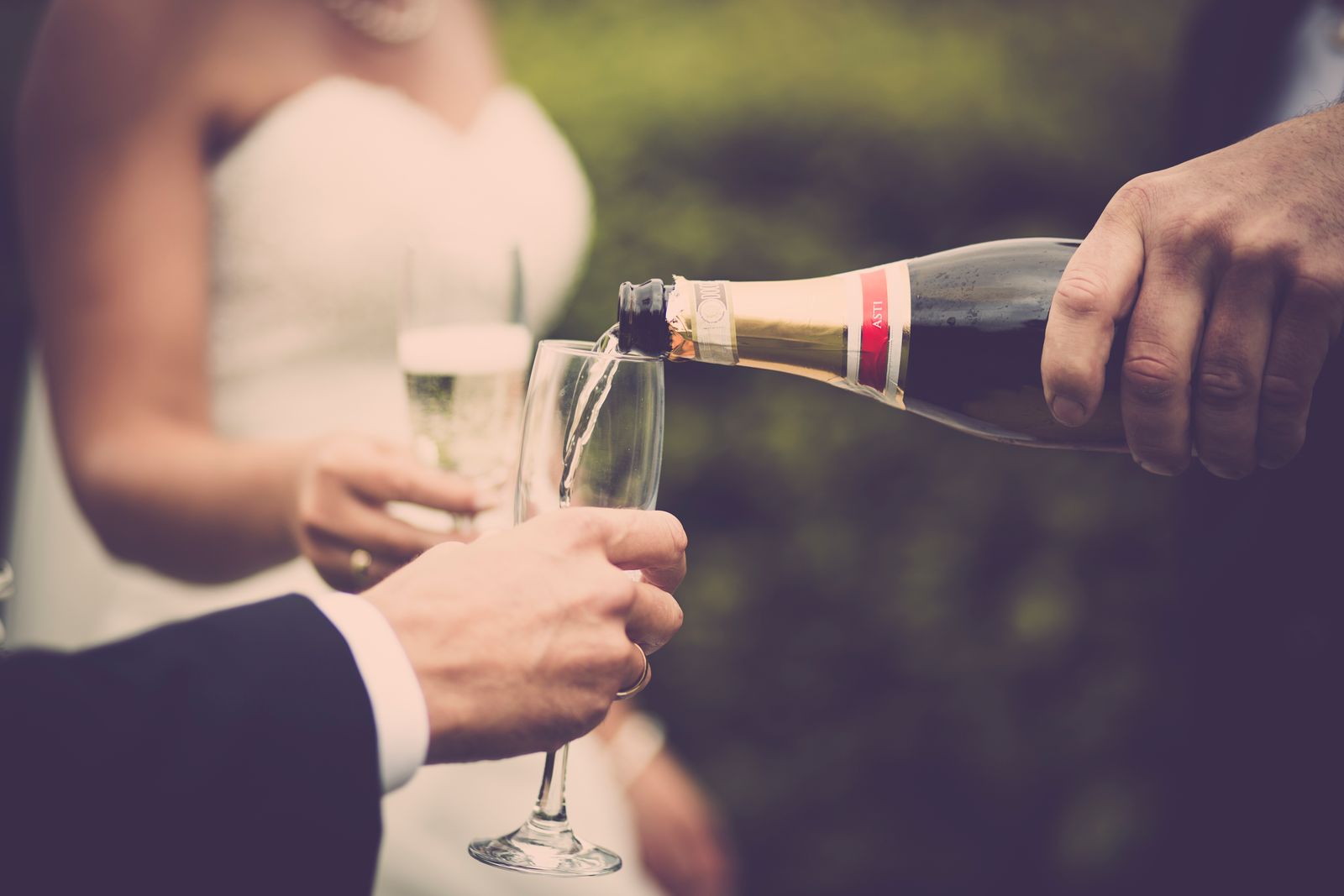 Groom pouring champagne for the bride at their wedding reception