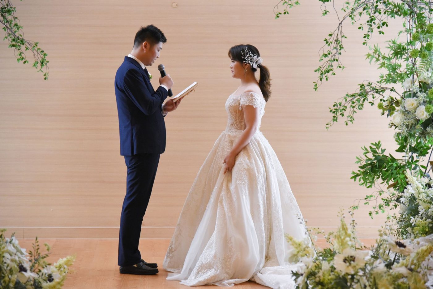Groom reading his wedding vows to his bride during an indoor ceremony