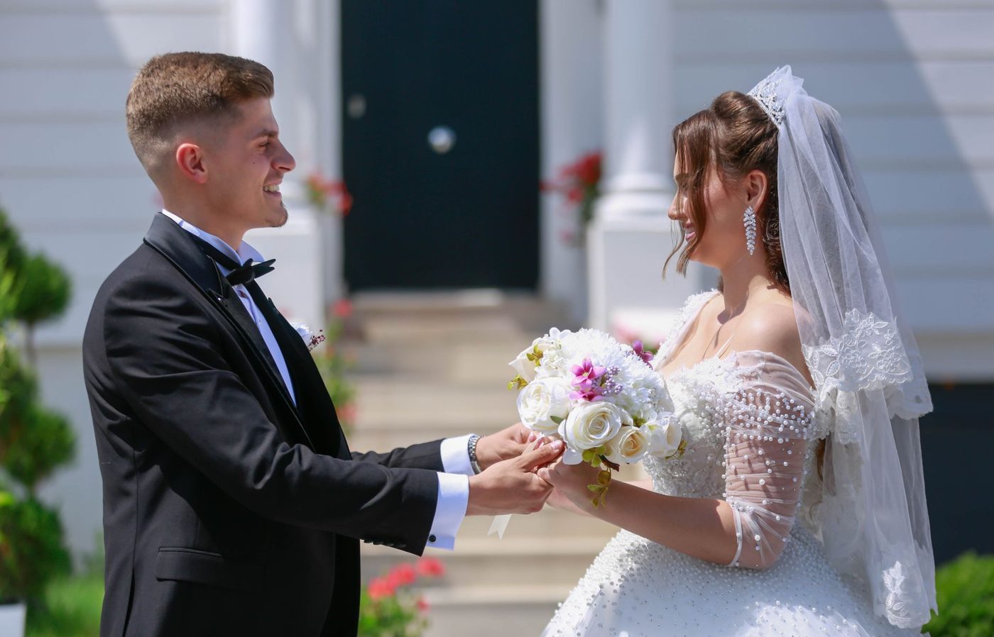 Couple holding hands and exchanging vows in front of an officiant at an outdoor wedding ceremony
