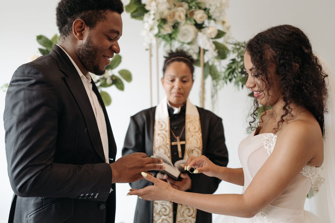 Bride and groom facing each other while reading personal vows at the altar
