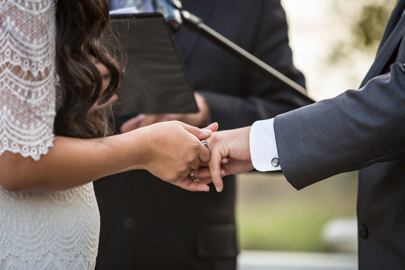 Couple facing each other and exchanging vows during an outdoor wedding ceremony