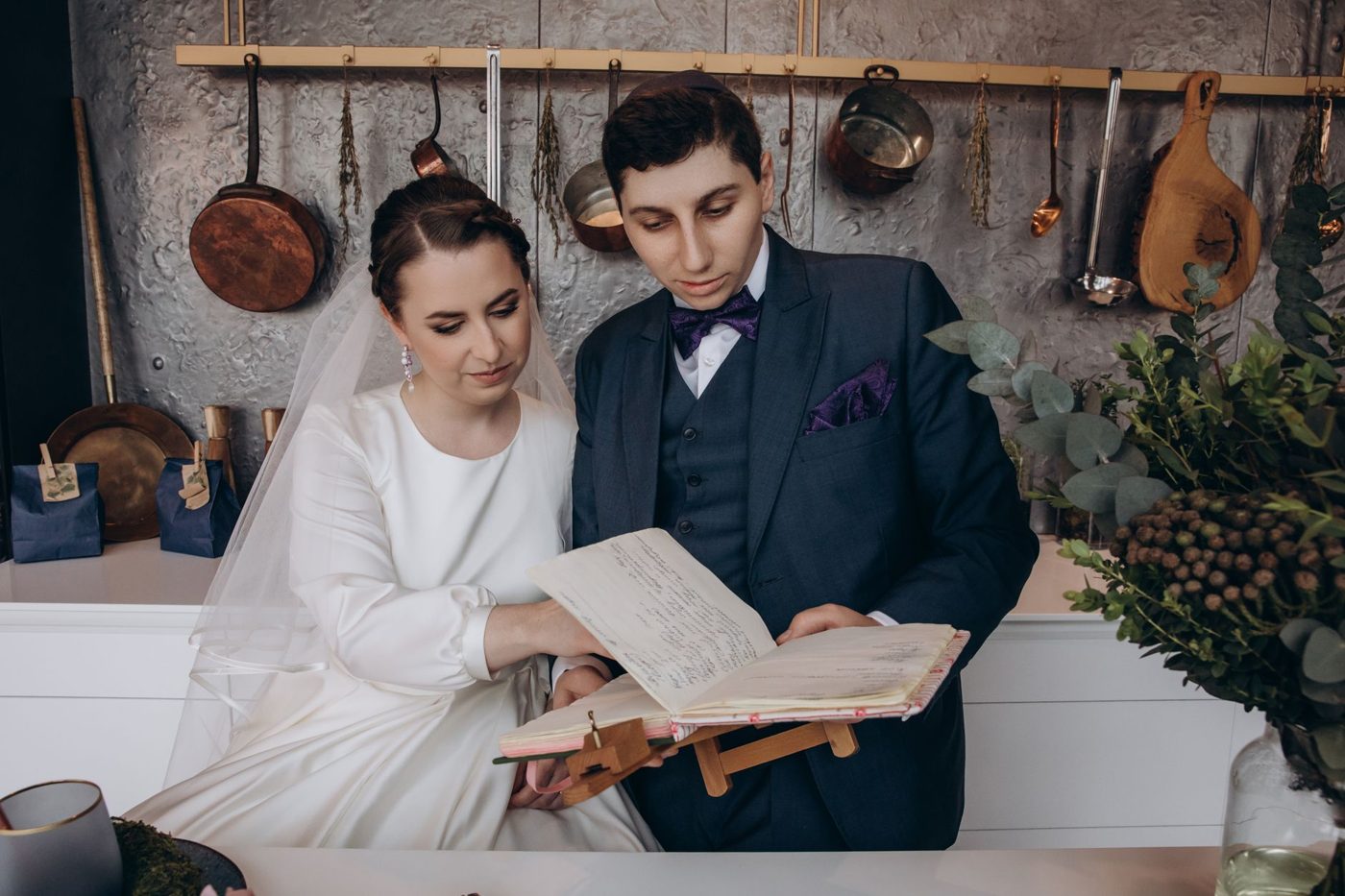 Engaged couple sitting at a table with notebooks, talking through their wedding ceremony plans