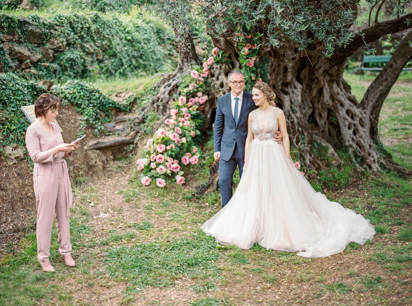 Groom reading his wedding vows to his bride at the altar while guests look on
